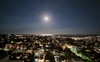 Night time view of the moon over the ocean 