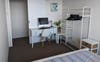 Desk, computer, clothes rack and double bed.